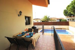 un patio con mesa y sillas junto a una piscina en Riumar 'Mar i Cel', 220m to beach, private pool, On-Site-Service, dog beach, en Riumar