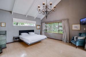a bedroom with a bed and a chandelier at The House Fourways in Sandton