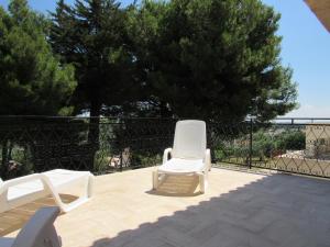 two white lawn chairs sitting on a patio at Casa il Giovane Alloro in Martina Franca