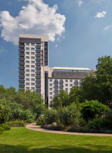 un edificio alto con un parque delante de él en Jumeirah Carlton Tower London, en Londres