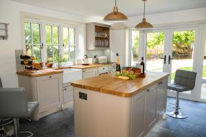 a kitchen with white cabinets and a wooden counter top at Inviting 5-Bed House in 1066 County - Battle in Battle