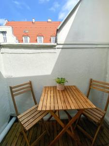 een houten tafel en 2 stoelen op een balkon bij Old Town Apartment in Gdańsk