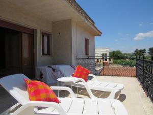 two white chairs and a table on a balcony at Casa il Giovane Alloro in Martina Franca +14 photos