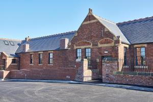 a red brick building with a black roof at No 2 at Simpson Street Apartments Sunderland in Sunderland