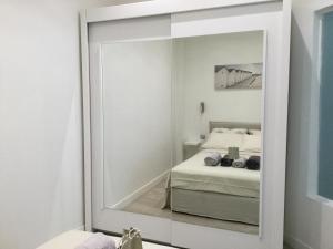a mirror in front of a bedroom with a bed at Carré d’Or super 2 pièces in Nice