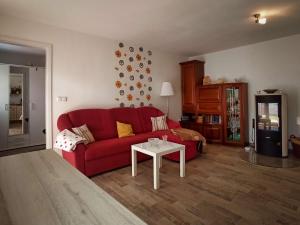 ein Wohnzimmer mit einem roten Sofa und einem Tisch in der Unterkunft Häuschen am Silbersee in Kittlitz
