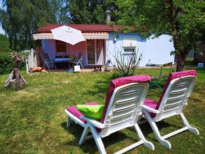 two chairs sitting in the grass in front of a house at Häuschen am Silbersee in Kittlitz +5 photos