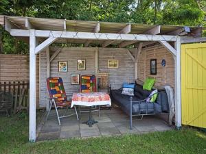 a pergola with a table and chairs in a backyard at Häuschen am Silbersee in Kittlitz