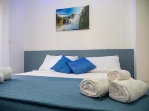1 dormitorio con 1 cama con toallas en biRose B&B Affittacamere en Otranto