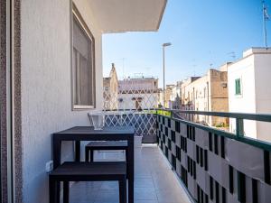 a balcony with two tables and a view of a city at biRose B&B Affittacamere in Otranto
