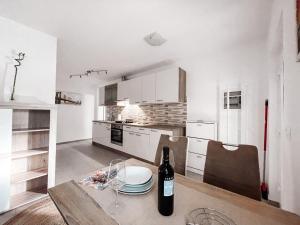 cocina con mesa y botella de vino en RIAD Apartments, en Zgornje Škofije
