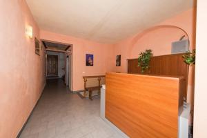 a hallway with pink walls and a wooden counter at Residence il Duomo in Lucca