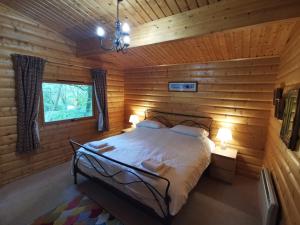a bedroom with a bed in a log cabin at Fern Lodge in Louth