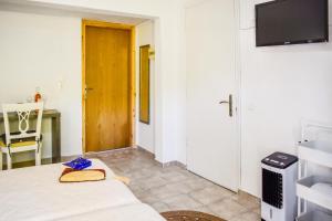 a room with a bed and a television and a table at BONSAI in Skiathos
