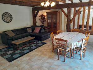 ein Wohnzimmer mit einem Tisch und einem Sofa in der Unterkunft Ravissante longère avec grand jardin et cheminée in Pellevoisin
