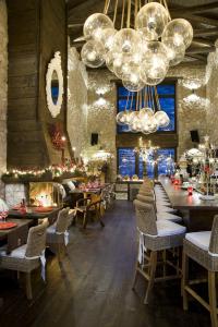 a restaurant with tables and chairs and a chandelier at Teresa Country Lodge in Eptalofos