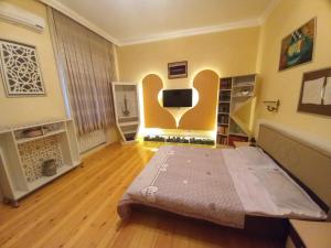 - une chambre avec un lit et une télévision dans l'établissement Yurd in Sheki, à Shaki