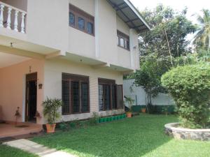 a house with a lawn in front of it at Samanala Garden Holiday Home in Hikkaduwa