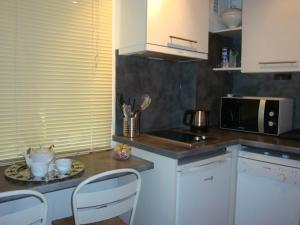 cocina con mesa, sillas y microondas en NEW ! Vue Petite Venise, Place to be - Parking, en Colmar