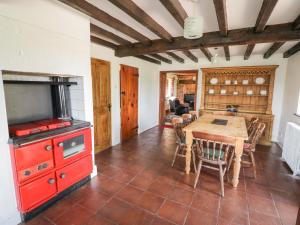 cocina con mesa de madera y estufa roja en Rowlands House, en Coalville