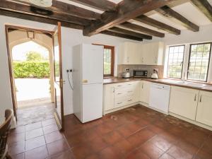 a kitchen with white cabinets and a white refrigerator at Rowlands House in Coalville