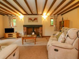 sala de estar con sofá y chimenea en Elsworthy Farm Cottage en Minehead