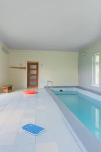 uma piscina com um tapete azul num quarto em Domek Kaszuby em Pobłocie