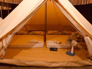 a tent with two beds in it with a fan at Mt Hamiguitan Escape Resort in La Union