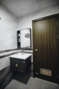baño con lavabo y puerta de madera en Khách sạn Hero Thanh Hóa en Thanh Hóa