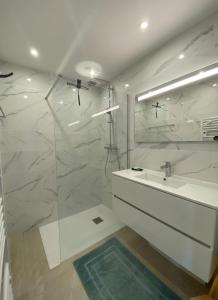 a white bathroom with a sink and a shower at Superbe T4 -Vue Mer- Tout Confort Refait à Neuf! in Bormes-les-Mimosas