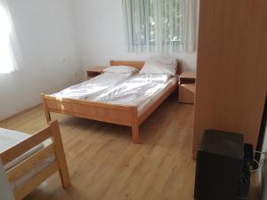 Cama en habitación con suelo de madera en Union apartmani Boracko jezero, en Konjic