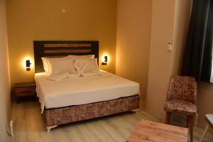 ein Schlafzimmer mit einem Bett und einem Stuhl in einem Zimmer in der Unterkunft Villa Sevilla in Kusadası