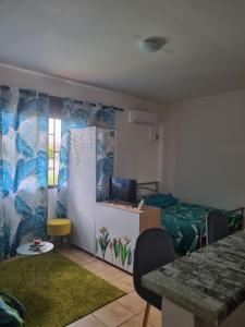 - une chambre avec un lit et une table dans l'établissement Studio Ça Mconvient, à Cayenne
