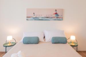 um quarto com uma cama com 2 candeeiros e um farol em Biggy Apartment em Olbia