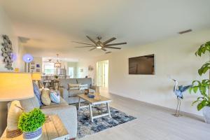 a living room with a couch and a tv on a wall at Jensen Beach Home with Private Dock and Ocean Access! in Jensen Beach