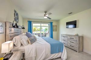 a bedroom with a bed and a dresser and a window at Jensen Beach Home with Private Dock and Ocean Access! in Jensen Beach