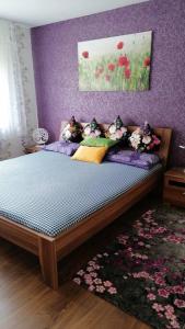 um quarto com uma cama com uma parede roxa em 2 Bedroom Apartment with Terrace & Beautiful View em Vöhrenbach