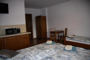 a room with two beds and a kitchen and a table at Miętusia Przystań - Wynajem Pokoi in Ciche