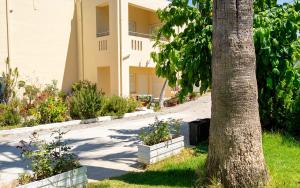 加藤達拉特索的住宿－齊諾維雅公寓，花丛前的树