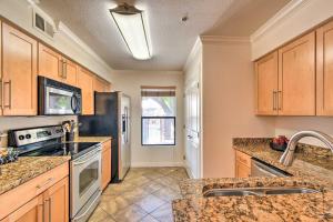 a kitchen with stainless steel appliances and wooden cabinets at 6 Mi to Downtown Phoenix Condo with Pool Access! in Phoenix