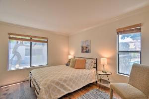 a bedroom with a bed and a chair and two windows at 6 Mi to Downtown Phoenix Condo with Pool Access! in Phoenix +19 photos