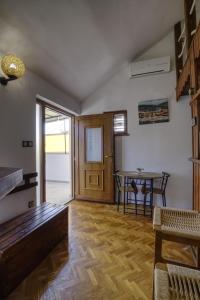 a living room with a table and a wooden floor at Apartman Tina in Grižane