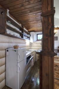 a kitchen with a white refrigerator and wooden ceilings at Apartman Tina in Grižane