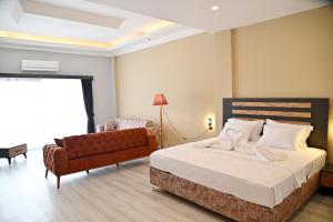 een hotelkamer met een bed en een bank bij Villa Sevilla in Kuşadası