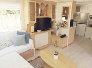 salon z białą kanapą i telewizorem w obiekcie 2 chambres à 15 mn de la mer en pleine nature Jacuzzi dispo du 01 avril au 15 octobre w mieście Anneville-sur-Scie +9 zdjęć