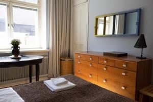 a bedroom with a dresser and a mirror on the wall at 2ndhomes 1BR Charming City apartment in Yrjönkatu in Helsinki