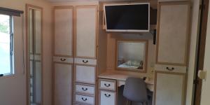 Pokój z biurkiem i telewizorem na ścianie w obiekcie 2 chambres à 15 mn de la mer en pleine nature Jacuzzi dispo du 01 avril au 15 octobre w mieście Anneville-sur-Scie