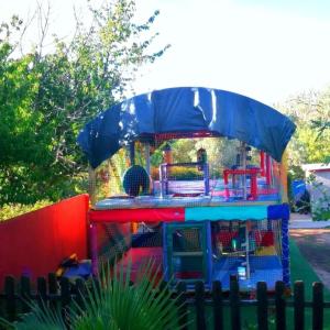 a bird cage with a play house in a yard at Aldea Vetonia Resort Familiar- PISCINAS-4 Zonas infantiles y deportivas 4 ACTIVIDADES AL DIA HASTA EL 8 DE SEPTIEMBRE CON MONITORES "SE ACEPTAN MASCOTAS DESDE EL 28 DE AGOSTO" in Hervás