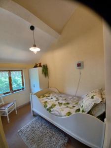 een slaapkamer met een wit bed in een kamer bij Gite un bout du sud in Châtel-Montagne