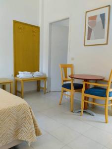 um quarto com uma cama, uma mesa e cadeiras em Alykes Family Resort em Lefkímmi